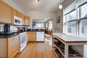 uma cozinha com electrodomésticos brancos e armários de madeira em Pet-Friendly Saint Paul Vacation Rental with Deck! em West Saint Paul