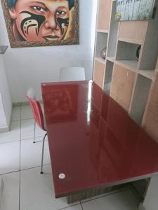 einen roten Schreibtisch in einem Zimmer mit einem Gemälde an der Wand in der Unterkunft Toca in Pipa