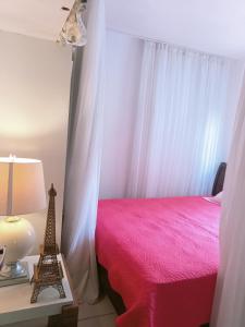 ein Schlafzimmer mit einem rosa Bett mit einer Lampe und dem Eiffelturm in der Unterkunft Toca in Pipa