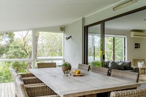 a dining room with a table and chairs at Narrawallee Beach House in Narrawallee