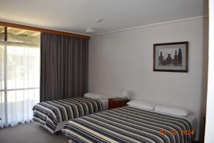 a hotel room with two beds and a window at Coonawarra Motor Lodge in Penola
