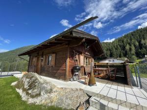 une cabane en rondins avec un grand rocher en face de celle-ci dans l'établissement Ferienhaus mit Weitblick, à Pill