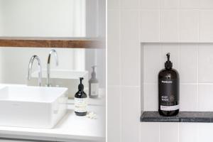 a bathroom with a sink and a bottle of soap at Narrawallee Beach House in Narrawallee +24 photos