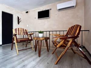 een kamer met 2 stoelen, een tafel en een tv bij Suite 5 -Terraza Vista Gran Parque de la Plancha in Mérida
