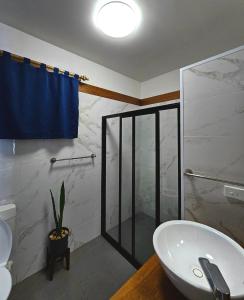 a bathroom with a sink and a glass shower at Sanalae Apartments in Honiara