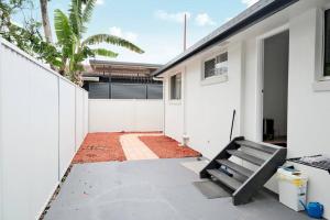 a courtyard of a house with a white fence at Fully renovated 3 bedroom house & Free Parking in Gold Coast