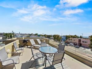 a patio with chairs and a table on a balcony at Ostend Escape - Multiple Patios, Large Rooftop, Water Views, Garage & Fast Wifi in San Diego