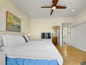 a bedroom with a large bed with a ceiling fan at Ostend Escape - Multiple Patios, Large Rooftop, Water Views, Garage & Fast Wifi in San Diego