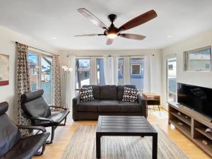 a living room with a couch and a ceiling fan at Ostend Escape - Multiple Patios, Large Rooftop, Water Views, Garage & Fast Wifi in San Diego