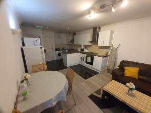 a kitchen and a living room with a table and a couch at London Ilford Rooms in Goodmayes