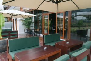a restaurant with green chairs and tables and umbrellas at Backyard Canggu in Canggu