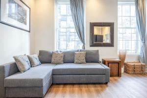 een woonkamer met een bank en een spiegel bij REFURBISHED QUIET 3 BEDROOM FLAT BY HIGH STREET,TRAMS and BUSES - OR 30 MINS WALK TO CENTRE in Edinburgh