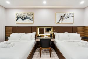 um quarto de hotel com duas camas e uma secretária em VIN HOTEL em Vinh Long