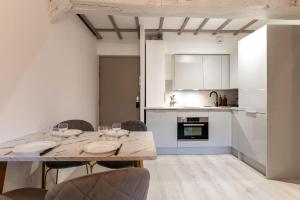 - une cuisine et une salle à manger avec une table et des chaises dans l'établissement Villa Caron - Appartements haut de gamme avec chambre hyper centre, à Rouen