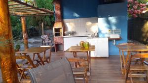 a kitchen and dining room with wooden tables and chairs at Vila Itacimirim in Itacimirim
