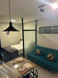 a room with a couch and a table and a bed at LOFTS CARIJOS CENTRO BH in Belo Horizonte