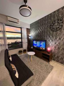 a living room with a couch and a flat screen tv at CASA ABODE - Jesselton Quay (Sea View) in Kota Kinabalu