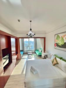 a bedroom with a large bed and a living room at Diny ApartHotel - Rooftop Pool - The Manor 2 in Ho Chi Minh City