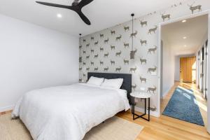 een slaapkamer met een wit bed en een muur met paardenkoppen bij Modern farmhouse in Cobargo