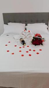a bed with a bunch of hearts and a bouquet of roses at Lindo loft decorado no centro c/ garagem in São Roque +15 photos