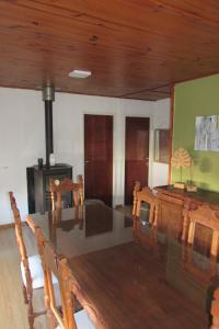 sala de estar con mesa de madera y fogones en Casa en Quequén hasta 5 personas en Quequén