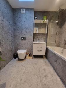 a bathroom with a toilet and a sink and a tub at Beckenham - Luxury One Bedroom Apartment With Two Baths And WC in Elmers End