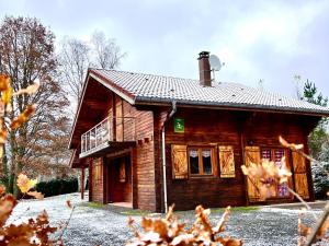 a small wooden house with a balcony on it at Chalet confortable avec cheminée à Taintrux - FR-1-589-222 in Taintrux