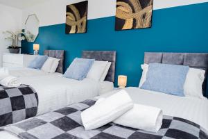 two beds in a room with blue walls at Wow Book Me 9 Beds 25 Baths Contractors,family! in Earley