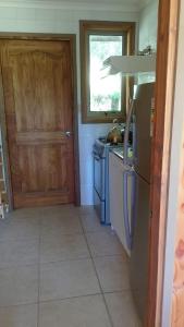 a kitchen with a stove and a refrigerator and a door at Cabañas Privadas en Pucon in Pucón