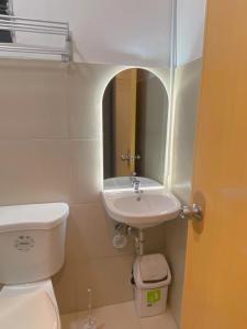 ein Badezimmer mit einem Waschbecken, einem WC und einem Spiegel in der Unterkunft Time To Sleep - Casa Ala Una in Butuan