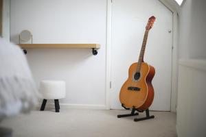 una guitarra apoyada en una puerta en una habitación en Private Parking & Pillow Paradice & With RR Housing, en Leamington Spa