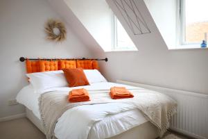 a bedroom with a bed with orange towels on it at Private Parking & Pillow Paradice With RR Housing in Leamington Spa