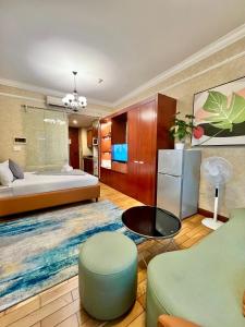 a bedroom with a bed and a couch and a table at Diny ApartHotel - Rooftop Pool - The Manor 2 in Ho Chi Minh City