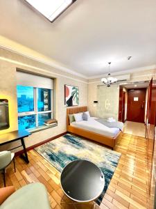 a bedroom with a bed and a table and a tv at Diny ApartHotel - Rooftop Pool - The Manor 2 in Ho Chi Minh City