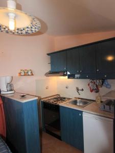 - une cuisine avec des placards bleus et un évier dans l'établissement Apartments by the sea Privlaka, Zadar - 22380, à Privlaka