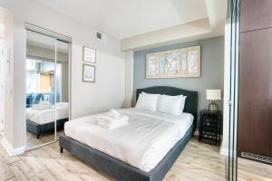 1 dormitorio con cama y espejo en Modern 1 bedroom sleeps 3 Yorkville STK en Toronto