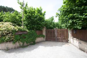 a fence with a wooden gate with trees and bushes at La Finestra sul Lago in Ronciglione