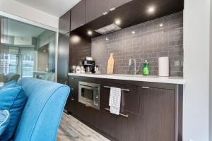 cocina con encimera y sofá azul en Modern 1 bedroom sleeps 3 Yorkville STK en Toronto