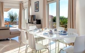 a dining room with a white table and white chairs at Holiday house with a swimming pool Hvar - 22428 in Hvar