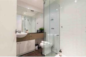 La salle de bains est pourvue de toilettes, d'un lavabo et d'une douche. dans l'établissement Bright City Views Melbourne Central Penthouse on Collins, à Melbourne