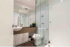 a bathroom with a toilet and a sink and a shower at Bright City Views Melbourne Central Penthouse on Collins in Melbourne +45 photos