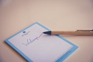 Ein Bleistift auf einem Stück Papier mit dem Wort "willkommen" in der Unterkunft Hotel Melissanthi in Paralia Dionisiou
