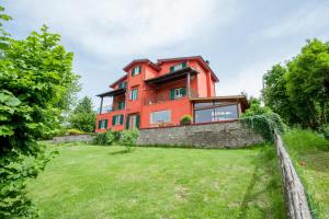 a red house on a stone wall with a yard at La Finestra sul Lago in Ronciglione