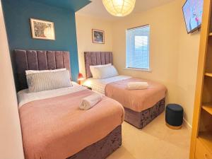 a room with two beds and a window at Noknokstay-Payler House-cozy 4 bedrooms in Sheffield