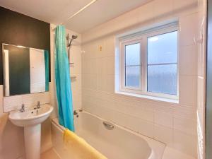 a bathroom with a sink and a bath tub and a window at Payler House Sheffield-WiFi -Large Parking Space-cozy 4 bedrooms in Sheffield +30 photos