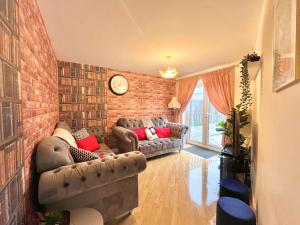 a living room with two couches and a brick wall at Payler House Sheffield-WiFi -Large Parking Space-cozy 4 bedrooms in Sheffield