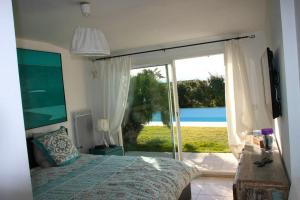 a bedroom with a bed and a sliding glass door at Villa élégante à Villelaure + Clim in Villelaure +7 photos