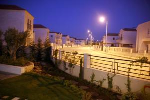 una strada di città di notte con recinzione e lampioni di Al Andulcia Airport Road Complex مجمع الاندلسية طريق المطار 