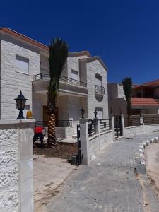 una casa con una palma di fronte di Al Andulcia Airport Road Complex مجمع الاندلسية طريق المطار 