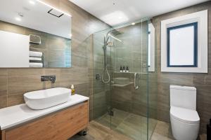 une salle de bain avec douche, lavabo et toilettes dans l'établissement Lakeside Luxury 2 Bedroom Apartment, à Wanaka